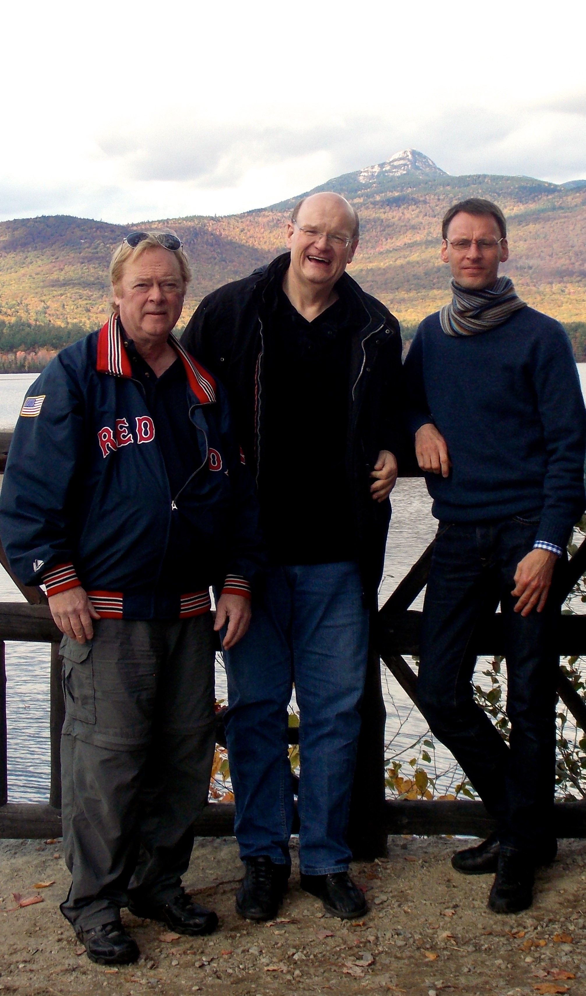 Dr. Morris, Frank Düppendbecker, Klaus Eldert Müller standing together in front of a river and a mountain.